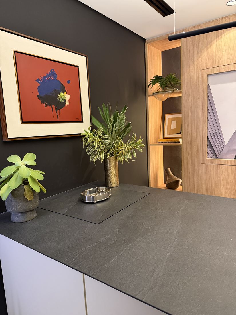Bancada de porcelanato escuro com quadro vermelho e nichos de madeira iluminados