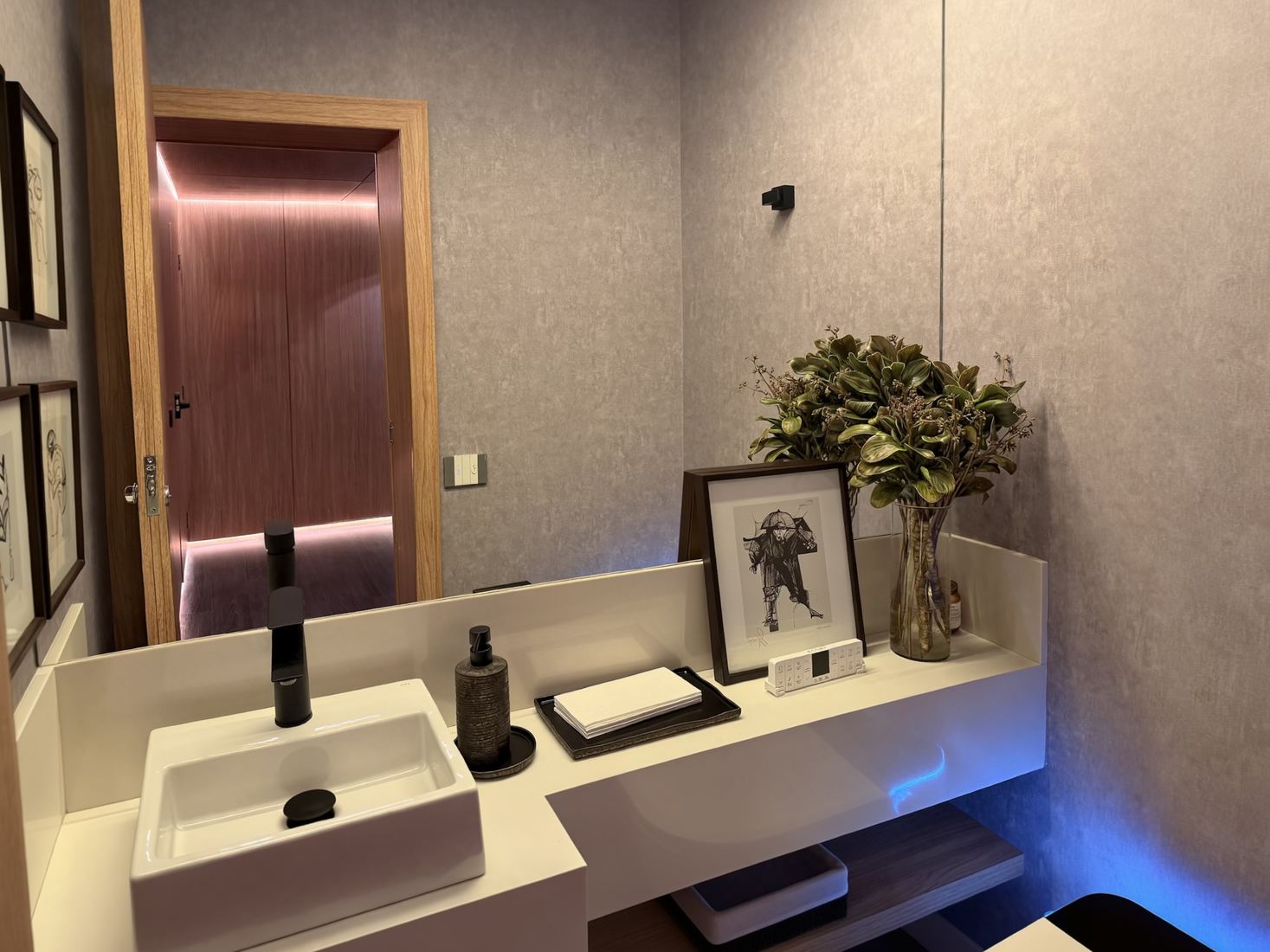 Lavabo do centro de experiências com iluminação de destaque na porta